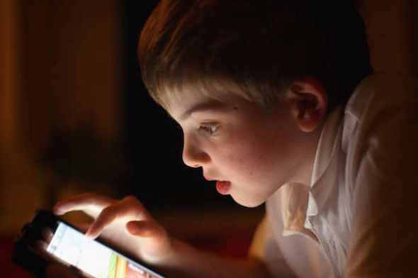 boy using smartphone in the dark