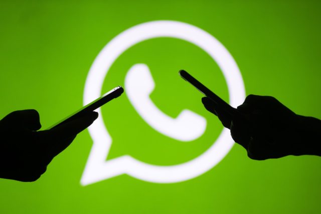 من iPhoneIslam.com، شعار WhatsApp مظلل على خلفية خضراء يد اثنين يقومون بالمحادثة عبر واتس آب.