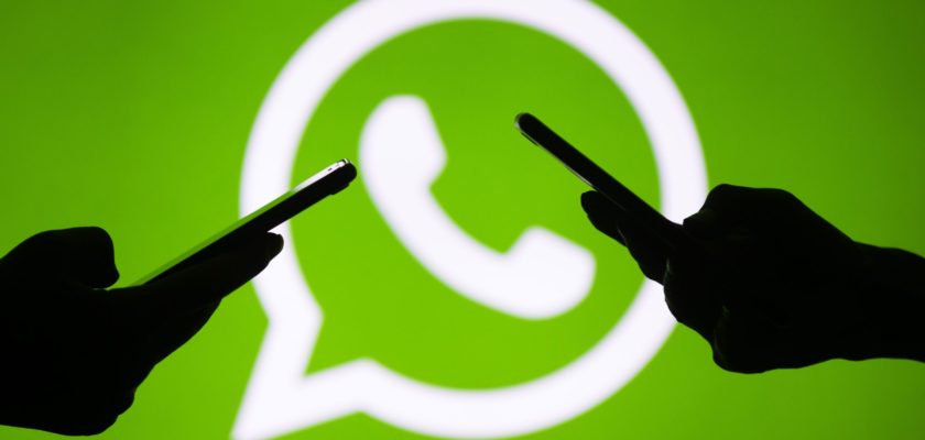 Desde iPhoneIslam.com, el logotipo de WhatsApp resaltado sobre un fondo verde de dos manos conversando en WhatsApp.