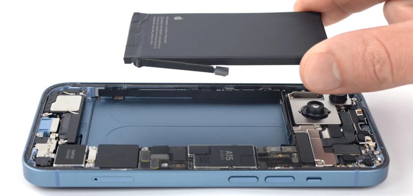 من iPhoneIslam.com، يقوم أحد الأشخاص بإزالة البطارية من جهاز iPhone 15.