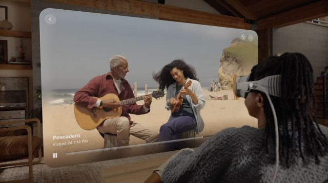 Da iPhoneIslam.com, una donna suona la chitarra davanti allo schermo TV mentre discute le caratteristiche distintive dell'iPhone 15 Pro rispetto all'iPhone 15 standard (Parte XNUMX).