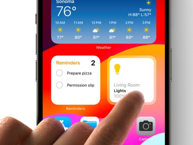 iPhoneIslam.com'dan Bir el, akıllı telefonun ana ekranını işaret ederek dizüstü bilgisayar uygulamasının özelliklerini vurguluyor.