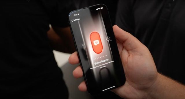 来自 iPhoneIslam.com，一个人拿着一部带有红色按钮的手机。
