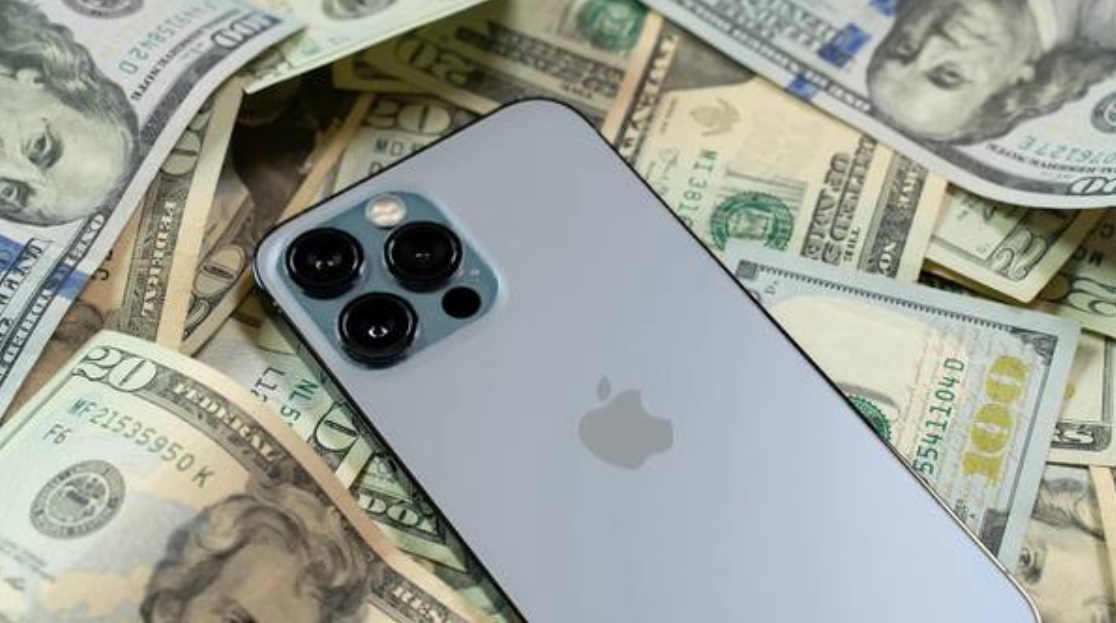 من iPhoneIslam.com، كومة من المال تحيط بجهاز iPhone 11 pro.