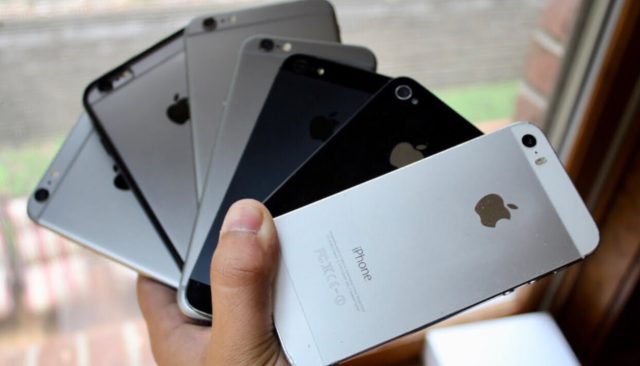 Von iPhoneIslam.com hält eine Person einen Haufen iPhones in verschiedenen Farben in der Hand.
