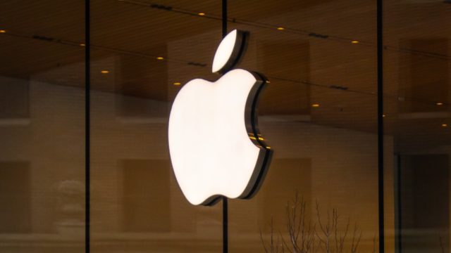 Từ iPhoneIslam.com, logo Apple được hiển thị nổi bật trên bức tường kính đầy phong cách.