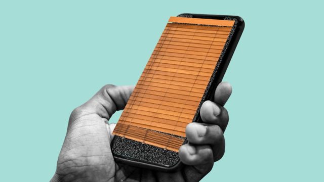 Z iPhoneIslam.com: Dłoń trzyma smartfon z ślepym drewnianym wyświetlaczem, który może być narażony na surfowanie po ramieniu.