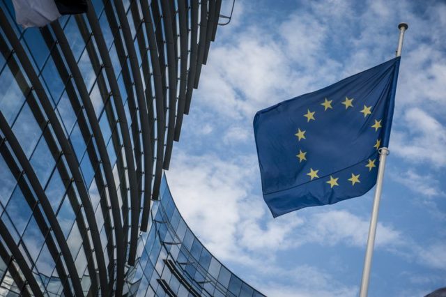 Z iPhoneIslam.com Flaga Unii Europejskiej powiewa przed budynkiem Komisji Europejskiej w Brukseli.