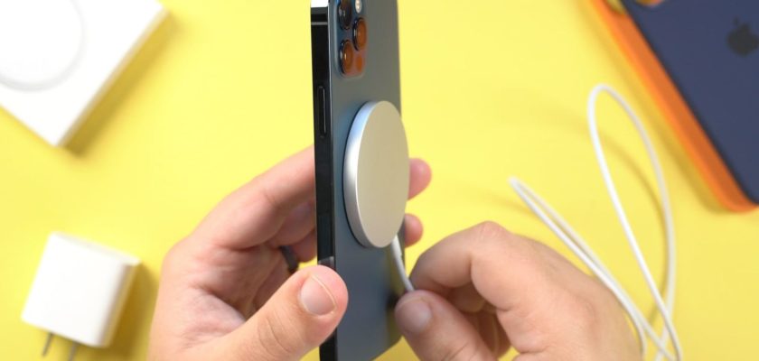 Dari iPhoneIslam.com, Seseorang memegang iPhone dengan pengisi daya MagSafe terpasang.