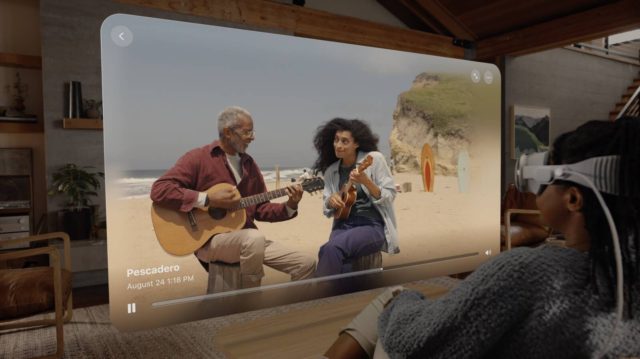 iPhoneIslam.com에서 한 남자와 여자가 ​​TV 화면 앞에서 기타를 연주하며 iPhone 15 Pro로 공간 영상을 포착하고 있습니다.