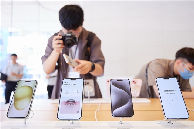 From iPhoneIslam.com, a man takes a photo of several iPhones on display.