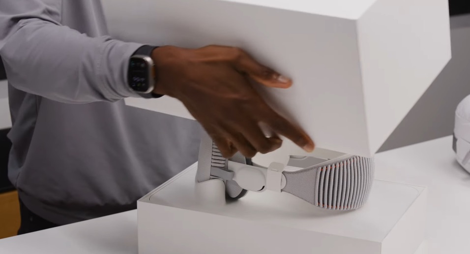 من iPhoneIslam.com، شخص يضع صندوق Vision Pro على الطاولة.
