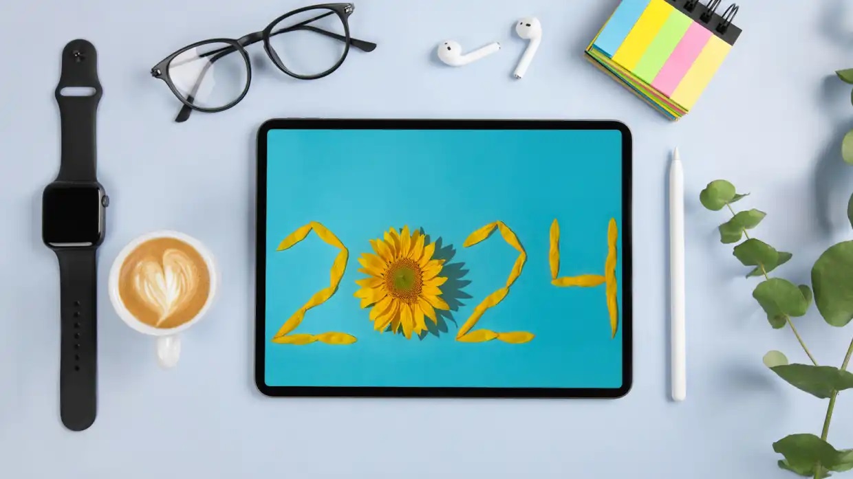 من iPhoneIslam.com،     الوصف: جهاز Apple iPad مكتوب عليه عام 2024 وفنجان قهوة بجانبه.