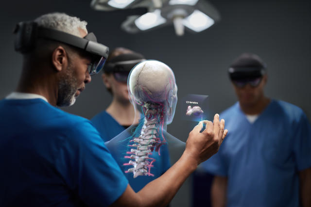 Da iPhoneIslam.com Un gruppo di chirurghi esplora un modello di realtà virtuale dello scheletro di un paziente utilizzando il visore per realtà aumentata di Apple.
