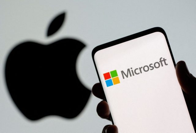 На iPhoneIslam.com людина тримає iPhone з логотипом Microsoft.