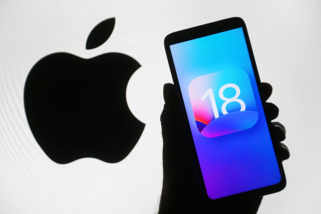 iPhoneIslam.com より、Apple 18 のロゴが付いた iPhone を持っている人が最新の iOS 18 を示しています。