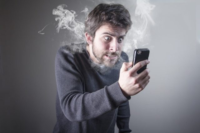 از iPhoneIslam.com، مردی از تلفن همراه خود لذت می برد و از آن سیگار می کشد.