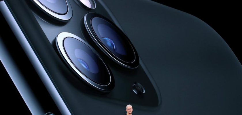 Desde iPhoneIslam.com, un ejecutivo en el escenario presenta una imagen grande del sistema de cámaras del teléfono inteligente al fondo, en nombre del servicio de pago de animación a los accionistas.