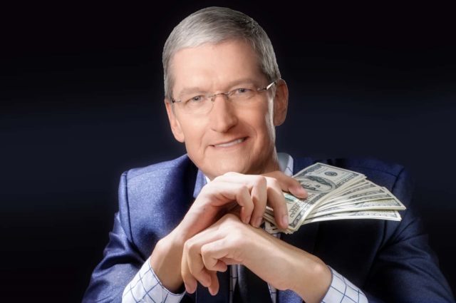 From iPhoneIslam.com, a businessman holds a fan of dollar bills with a confident smile, bragging that every minute spent on Apple products earns him more.