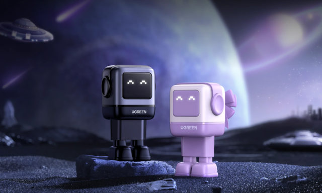 iPhoneIslam.com سے، دو یوگرین برانڈڈ روبوٹ کردار ایک اسٹائلائزڈ اسپیس لینڈ اسکیپ میں پس منظر میں اسپیس شپ کے ساتھ۔