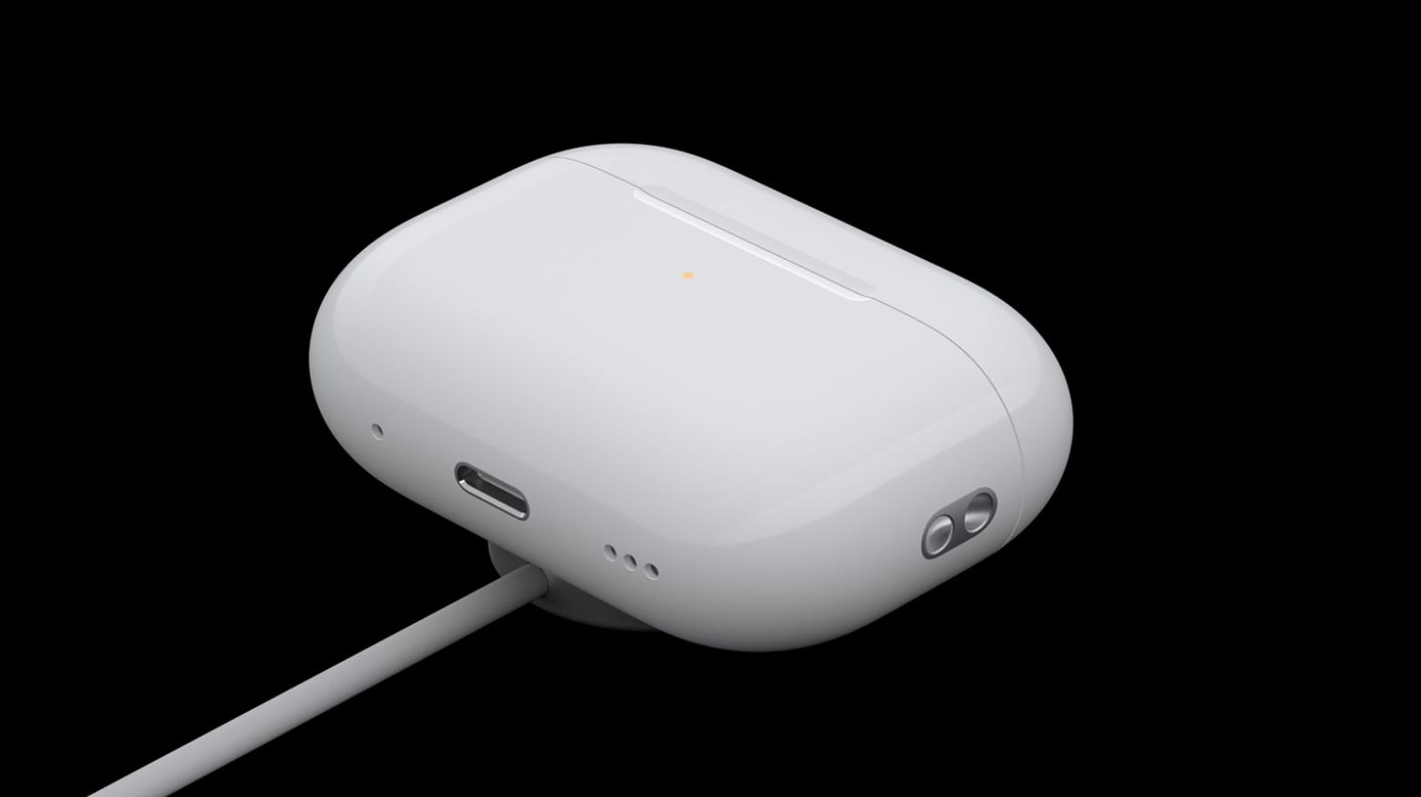 من iPhoneIslam.com، علبة شحن لاسلكية بيضاء لسماعات AirPods 4 مع ضوء مؤشر LED، متصلة بكابل شحن، على خلفية سوداء.