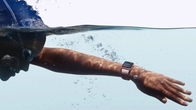 من iPhoneIslam.com، سباح يستخدم ساعة أبل أثناء السباحة تحت الماء، مع التركيز على الذراع والمشاهدة مع وجود فقاعات حولها.