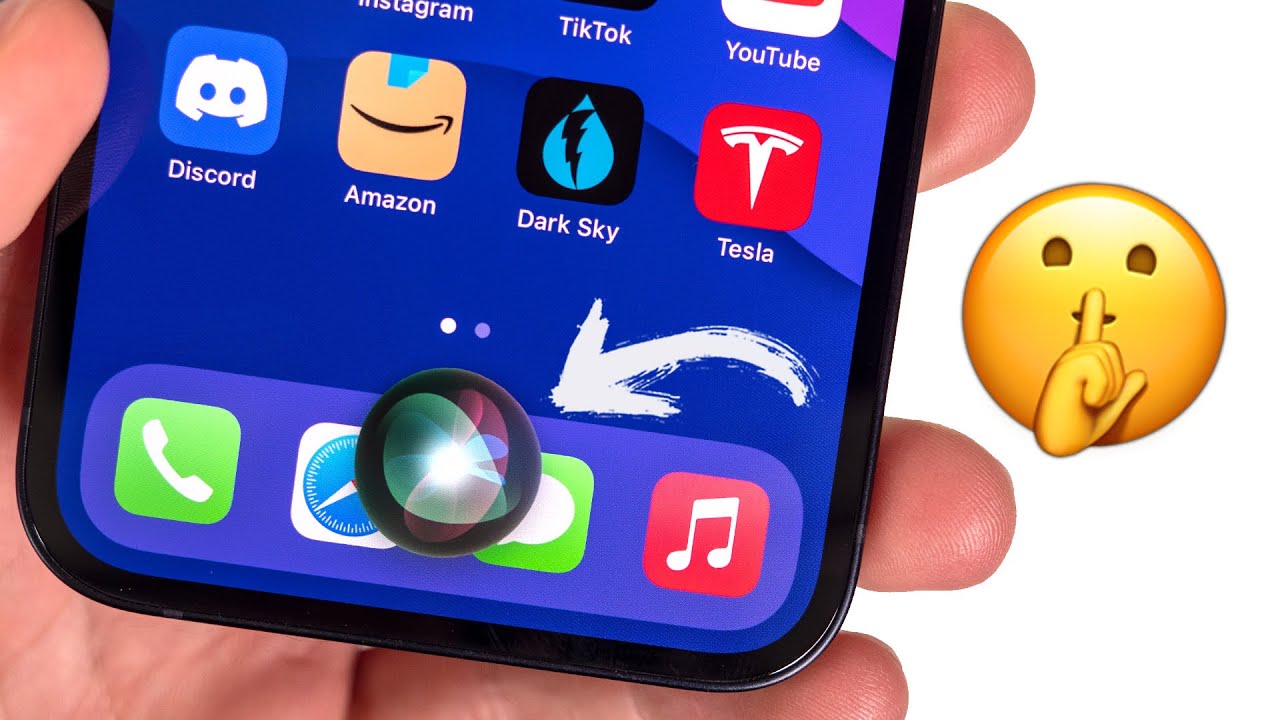 Dari iPhoneIslam.com, Tangan yang memegang iPhone menampilkan berbagai ikon aplikasi dengan penekanan pada aplikasi Siri, disertai emoji "diam".