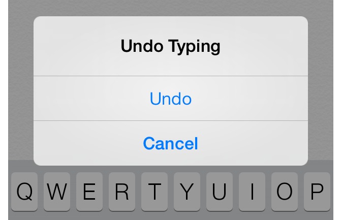 من iPhoneIslam.com، شاشة آي فون تعرض نافذة منبثقة بها ثلاثة خيارات: "التراجع عن الكتابة" و"التراجع" و"الإلغاء" فوق لوحة مفاتيح Qwerty.