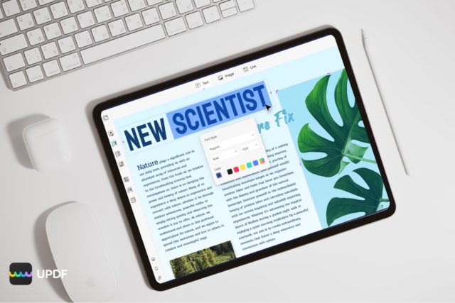 Van iPhoneIslam.com, een bovenaanzicht van een tablet met een artikel uit 'Nieuwe Wereld' op een wit bureau, omgeven door een toetsenbord, muis en groene bladeren. Op het scherm wordt ook de UPDF-editorinterface weergegeven