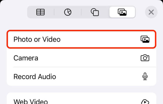 من iPhoneIslam.com، واجهة مستخدم تعرض خيارات الوسائط: "صورة أو فيديو" مظللة باللون الأحمر، و"الكاميرا"، و"تسجيل الصوت"، مع وجود شريط أدوات بالأعلى، مما يجعلها مثالية لمستخدمي الآي فون.