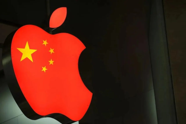 من iPhoneIslam.com، يتم عرض شعار Apple باللون الأحمر مع نجوم صفراء، يشبه العلم الصيني، على خلفية داكنة، ويعرض أحدث تحديث لـ Mac Studio.