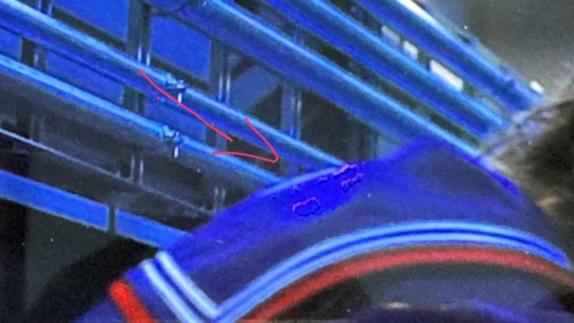من iPhoneIslam.com، يقف شخص يرتدي سترة زرقاء بالقرب من قضبان معدنية، مع سهم أحمر يشير إلى نقطة مبللة على كتف السترة، كما هو موضح في أخبار هذا الأسبوع.