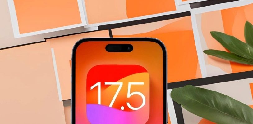 من iPhoneIslam.com، تعرض شاشة الهاتف الذكي الرقم "17.5" على خلفية متدرجة باللونين البرتقالي والوردي، مما يشير إلى آخر تحديث لنظام iOS 17.5. تم وضع الهاتف مقابل مستطيلات ورقية متداخلة باللونين البرتقالي والوردي مع وجود أوراق خضراء في الزاوية، مما يسلط الضوء على ميزاته الجديدة.
