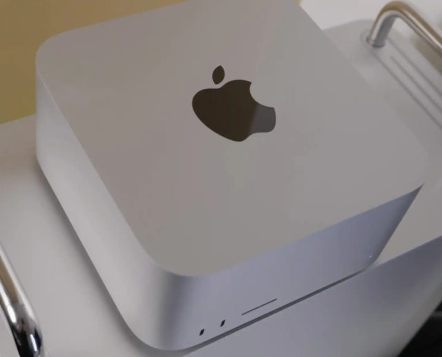 من iPhoneIslam.com، كمبيوتر Apple Mac Mini باللون الفضي على مكتب، ويتميز بشعار Apple في الأعلى ومنافذ USB في الأمام. اطلع على عروض مميزة جديدة للحصول على عروض رائعة على أجهزة أخرى مثل Mac Pro وMac Studio.