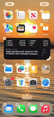 From iPhoneIslam.com, An animated image of the iPhone home screen in edit mode, showing app icons with a sunset beach background. The icons jiggle slightly, and some display red minus signs indicating they can be removed. This new feature is part of the iOS 18 update, enhancing the home screen experience.