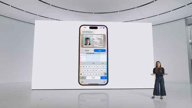 من iPhoneIslam.com، يقف أحد الأشخاص على خشبة المسرح بجوار شاشة كبيرة تعرض هاتفًا مزودًا بواجهة التحقق من الهوية وإدخال البيانات.
