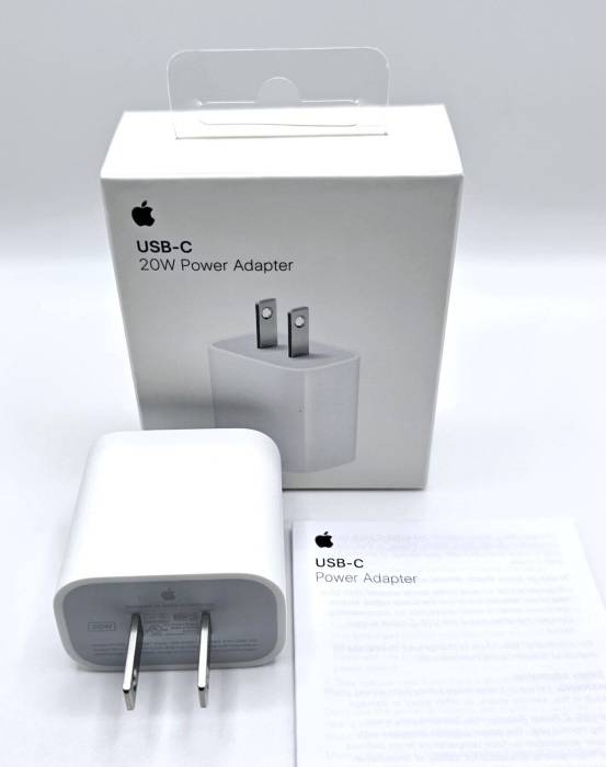 На сайте iPhoneIslam.com показан адаптер питания Apple USB-C мощностью 20 Вт с упаковкой и руководством по эксплуатации на белом фоне, который идеально подходит для быстрой зарядки и увеличения срока службы аккумулятора вашего устройства.