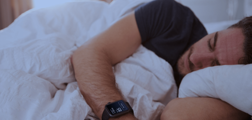 Da iPhoneIslam.com, Una persona che indossa un Apple Watch Ultra 3 dorme in un letto, appoggiata su lenzuola bianche con la testa su un cuscino.