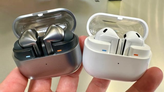 From iPhoneIslam.com, a close-up of two different wireless earbud cases; One is in metallic gray with metal earbuds, and the other is white with white earbuds. Both cases are open, revealing sleek designs that mimic popular brands like Samsung and Apple.