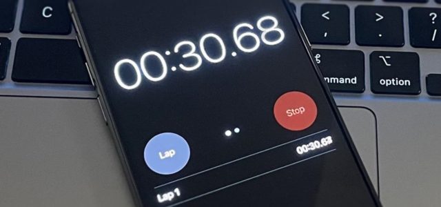 From iPhoneIslam.com A smartphone displaying a stopwatch reading 30.68 seconds is placed on a laptop keyboard. Featuring the iOS 18 update, the screen displays “Lap” and “Stop” options, and showcases the app’s signature feature for improved time tracking.