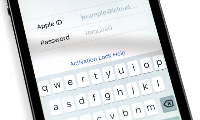 From iPhoneIslam.com, a close-up of a smartphone screen showing the Apple ID login interface, with fields for the ID and password, and a keyboard at the bottom. Beware of iPhone hacking when sharing your personal information.