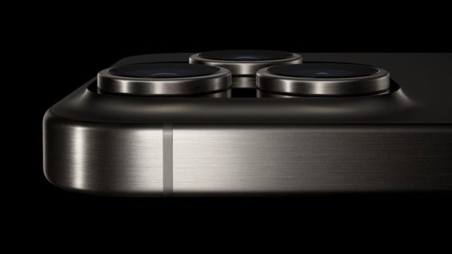 From iPhoneIslam.com, a close-up shot of the sleek iPhone 16 corner showing three camera lenses with camera enhancements and a metallic finish on a black background.