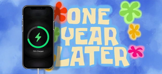 من iPhoneIslam.com، هاتف ذكي يظهر شحن بنسبة 75% مع نص "One Year Later" في الخلفية وأشكال زهور ملونة، تسلط الضوء على شحن بطارية آي فون.