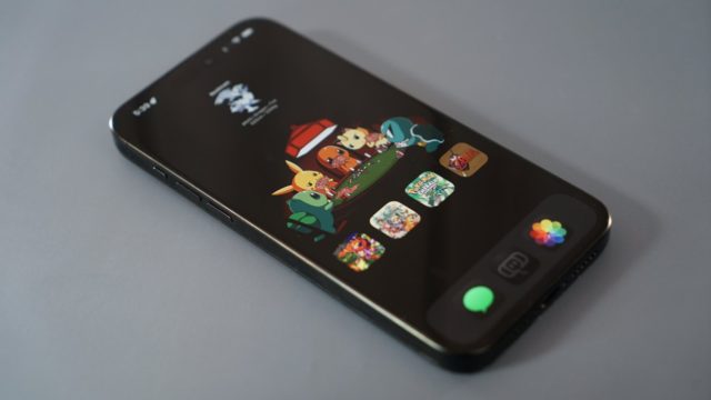 From iPhoneIslam.com, The iOS 18 smartphone displays a home screen with colorful animated character icons and apps on a gray surface, showing ways to customize the home screen.