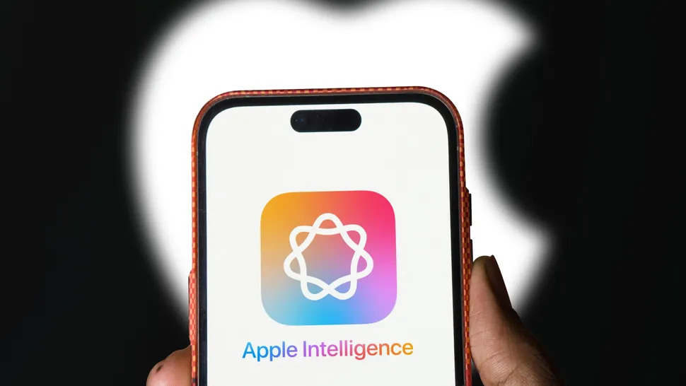 من iPhoneIslam.com، تحمل اليد هاتفًا ذكيًا يعرض شعار "Apple Intelligence" على الشاشة، على خلفية شعار Apple المتوهج، ويتكامل بشكل سلس مع نظام iOS 19 للحصول على تجربة مستخدم محسنة.