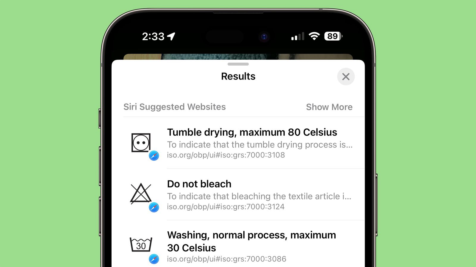 من iPhoneIslam.com، شاشة الهاتف الذكي تعرض رموز العناية بالغسيل: التجفيف بالمجفف بحد أقصى 80 درجة مئوية، لا تستخدم المبيضات، الغسيل العادي بحد أقصى 30 درجة مئوية.