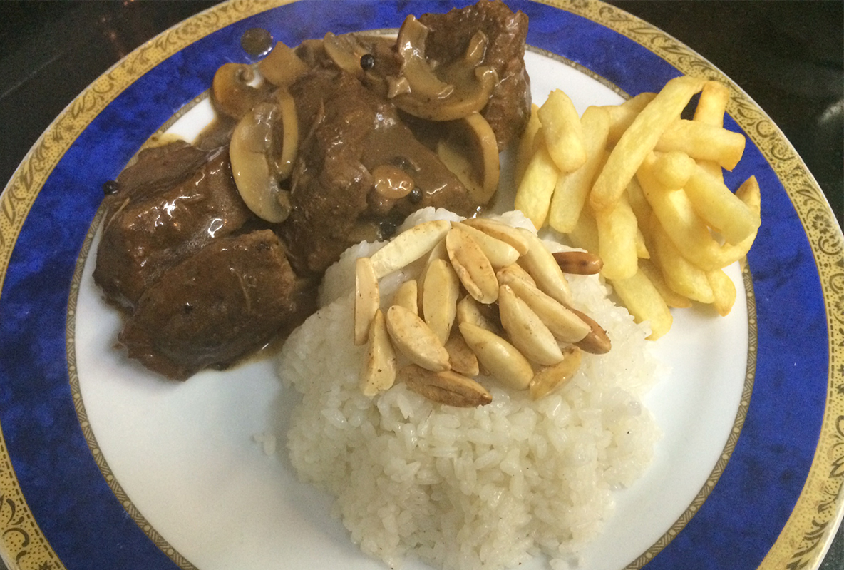 من iPhoneIslam.com، طبق مع مرق اللحم البقري والفطر والأرز الأبيض المغطى بالمكسرات والبطاطس المقلية على طبق مطلي باللونين الأزرق والذهبي، يظهر في صور طعام على تطبيق تطبيق الطعام ليجسد أشهد أشهى الأطباق.