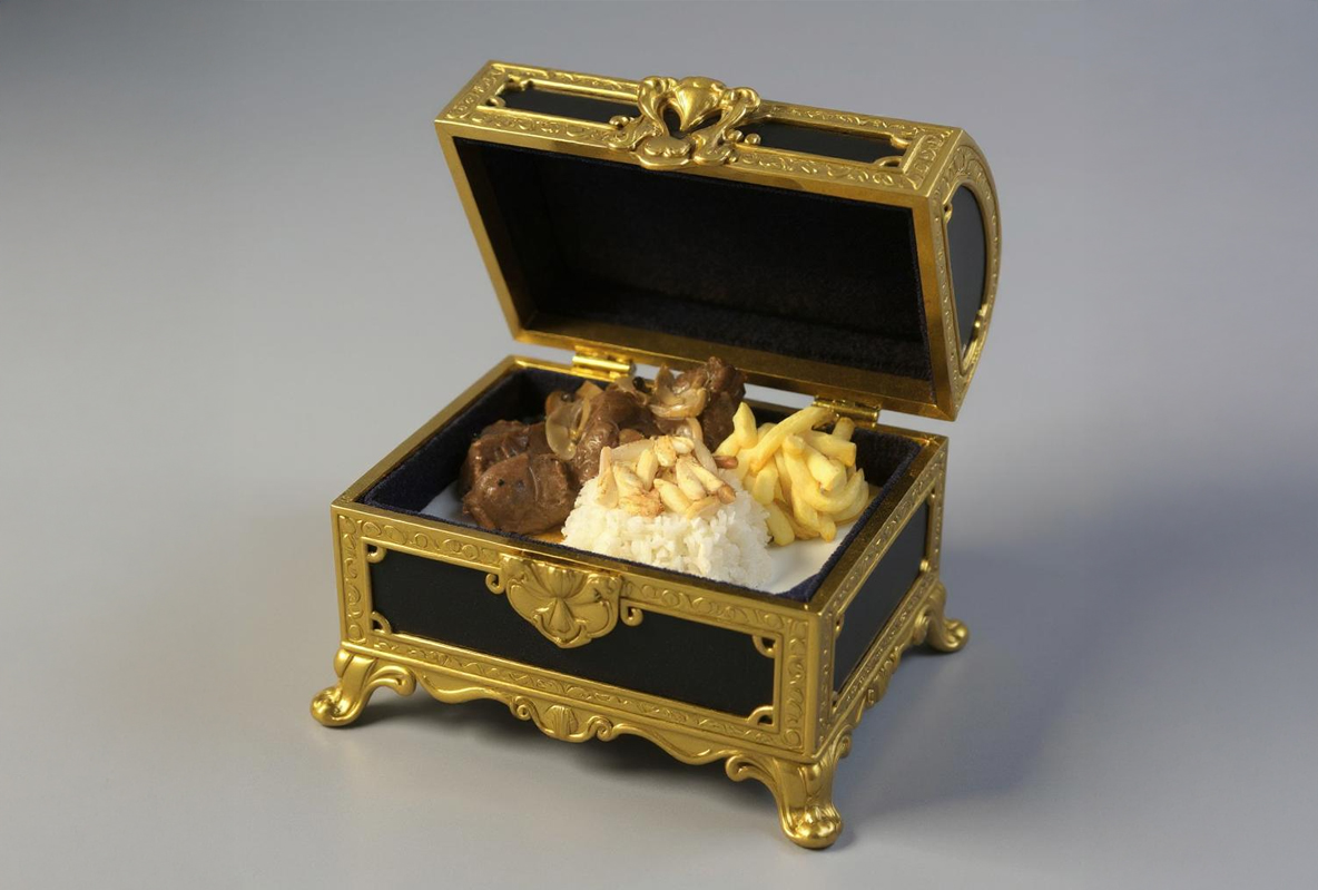 من iPhoneIslam.com، كما يوجد صندوق مجوهرات مزخرف باللونين الذهبي والأسود يحتوي على وجبة من اللحم والأرز والبطاطس المقلية - وكلها مصورة في صور من تطبيق فودوجينيك بدلاً من الجواهر المعتادة.