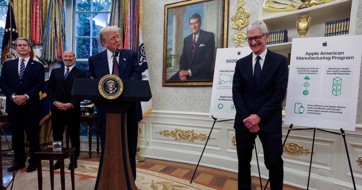 من iPhoneIslam.com، الرئيس السابق دونالد ترامب يتحدث على منصة في المكتب البيضاوي إلى جانب تيم كوك, بينما تُعرض ملصقات برنامج تصنيع شركة آبل - مع تسليط الضوء على أخبار التقنية ملخص لشهر أغسطس 2024.