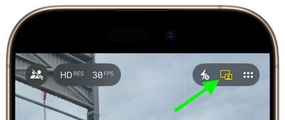 من موقع فون إسلام: صورة مقرّبة لشاشة كاميرا آي فون 17 تظهر فيها أيقونات الفلاش والصور الحية، مظللة بسهم أخضر في الزاوية اليمنى العليا - مثالية لتسجيل الفيديو والتقاط كل التفاصيل.